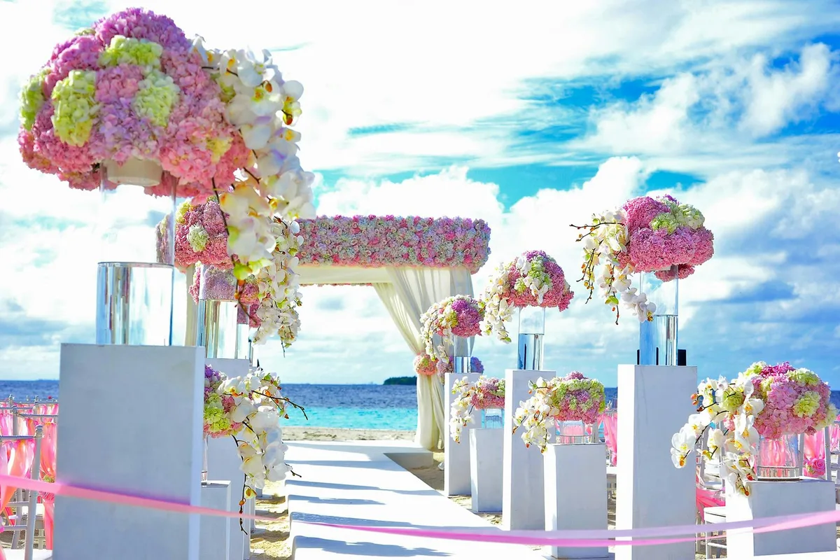 Strandhochzeit mit Blumenarrangements und Himmelblau-Farbpalette