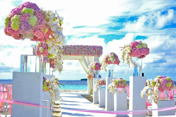 Décoration de mariage sur la plage avec compositions florales vibrantes au bord de la mer