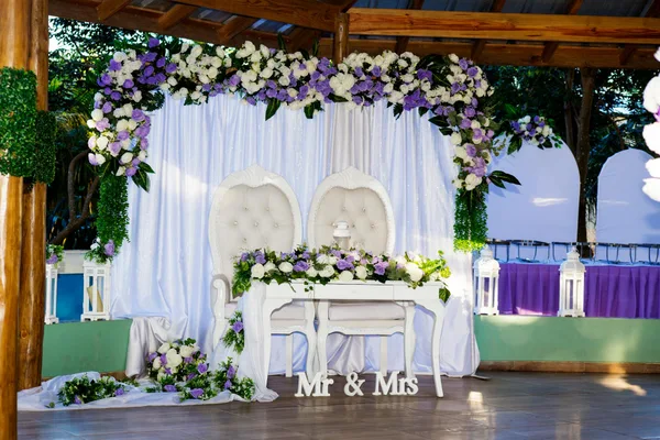 Lieu de mariage extérieur décoré d'arches florales et de chaises