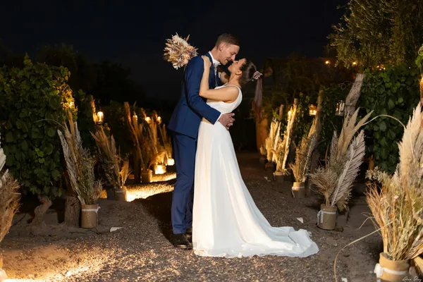 Brautpaar umarmt sich bei beleuchteter Weinberg-Hochzeit in Mendoza, Argentinien