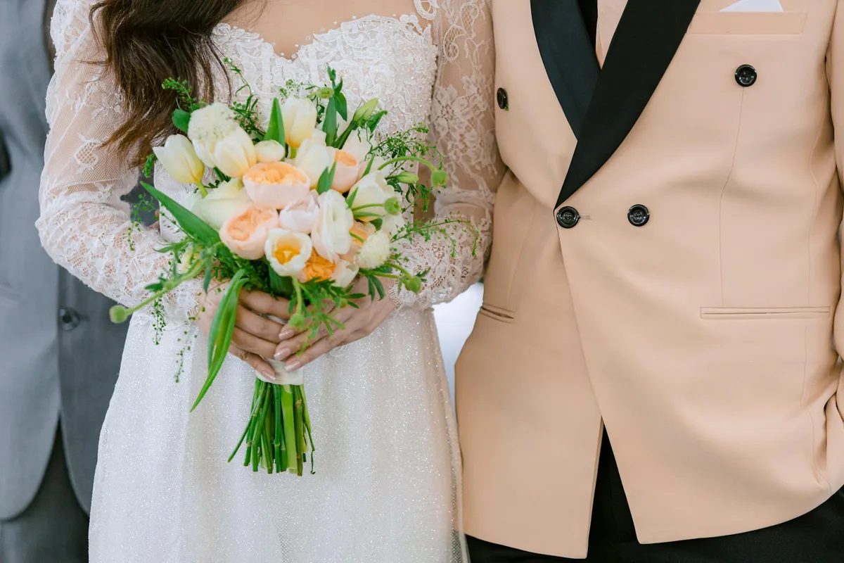 Sposi con bouquet floreale vibrante, eleganza e romanticismo