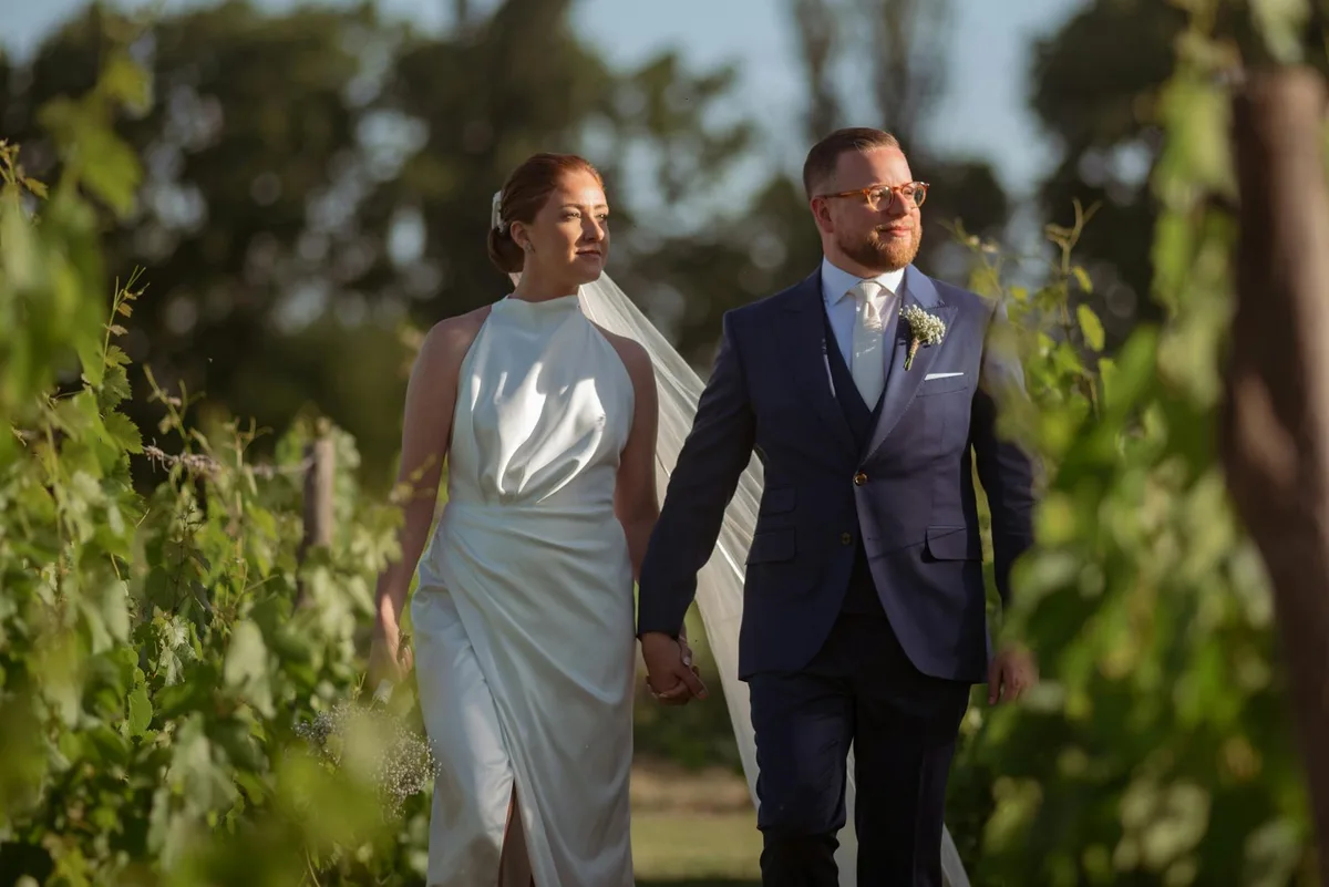 Sposi mano nella mano in un vigneto rigoglioso a Mendoza