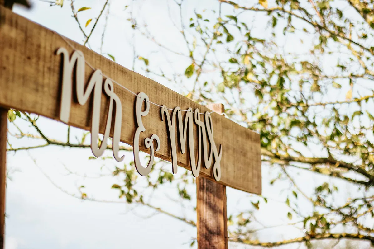 Charmantes 'Mr & Mrs'-Schild im Freien an einem sonnigen Tag für rustikale Hochzeiten
