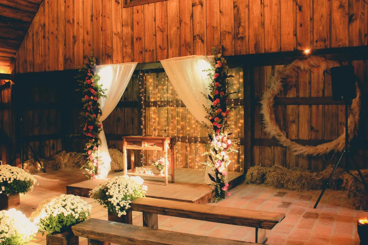 Charmante rustikale Scheunenhochzeit mit Blumenaltar und warmer Beleuchtung