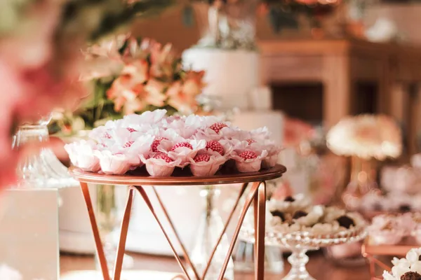 Close-up of beautifully arranged decorative treats on a wedding dessert table in pastel colors.
