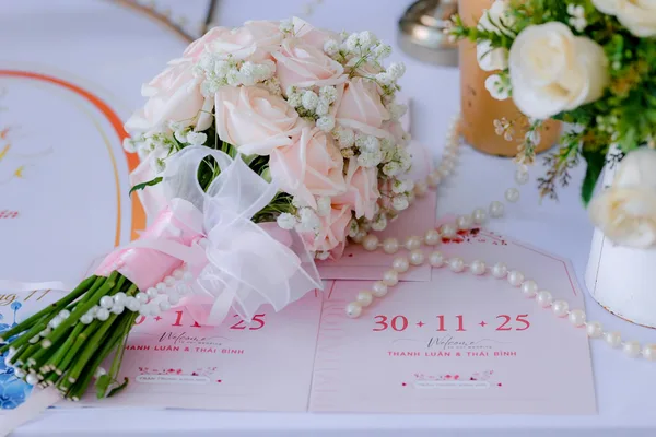 핑크 장미 부케와 웨딩 초대장이 있는 로맨틱 웨딩 테이블