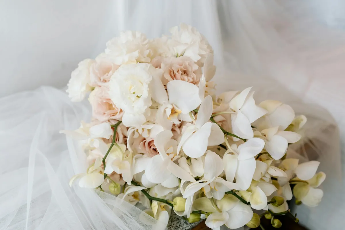 Mazzo di orchidee bianche e rosa cipria, perfetto per nozze eleganti e romantiche.