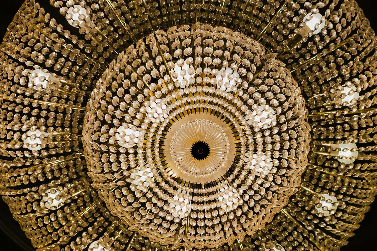 Prospettiva drammatica di lampadario di cristallo ornamentale dal basso, dettagli intricati.