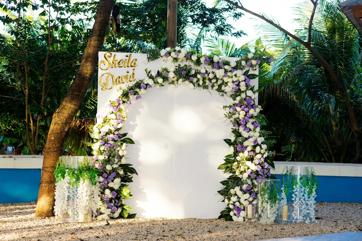 Arco nuziale elegante con fiori viola e bianchi per cerimonia in spiaggia a Puerto Plata