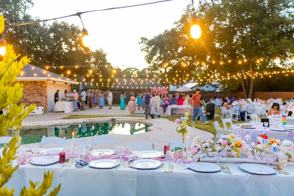 Festa all'aperto con lucine, tavole eleganti e sfondo piscina