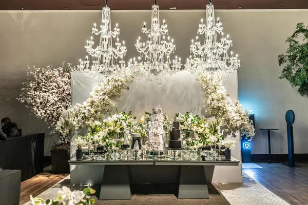 奢华婚礼现场，璀璨吊灯与繁花装饰，银色与深橄榄绿配色