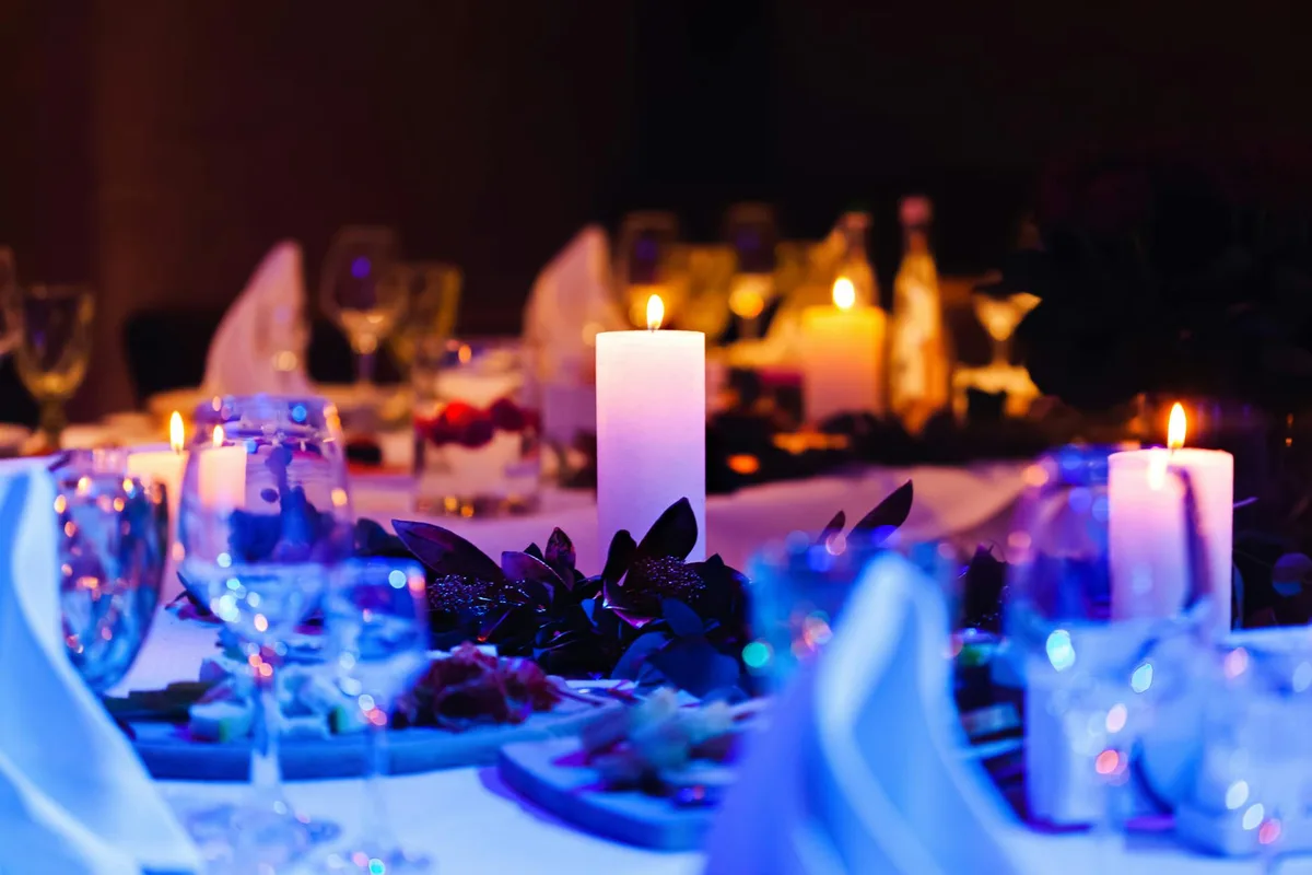 Cena romantica a lume di candela con calici e decorazioni floreali per occasioni speciali