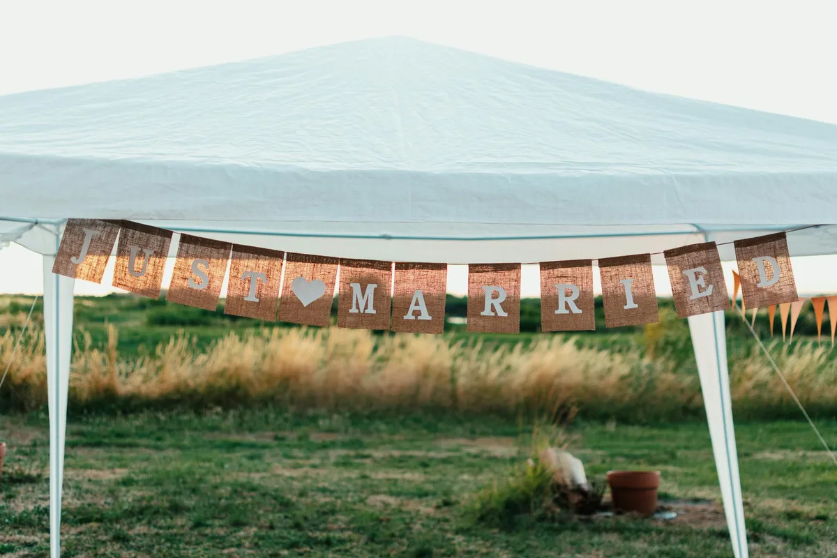 Insegna rustica 'Just Married' in location nuziale all'aperto con ambiente naturale