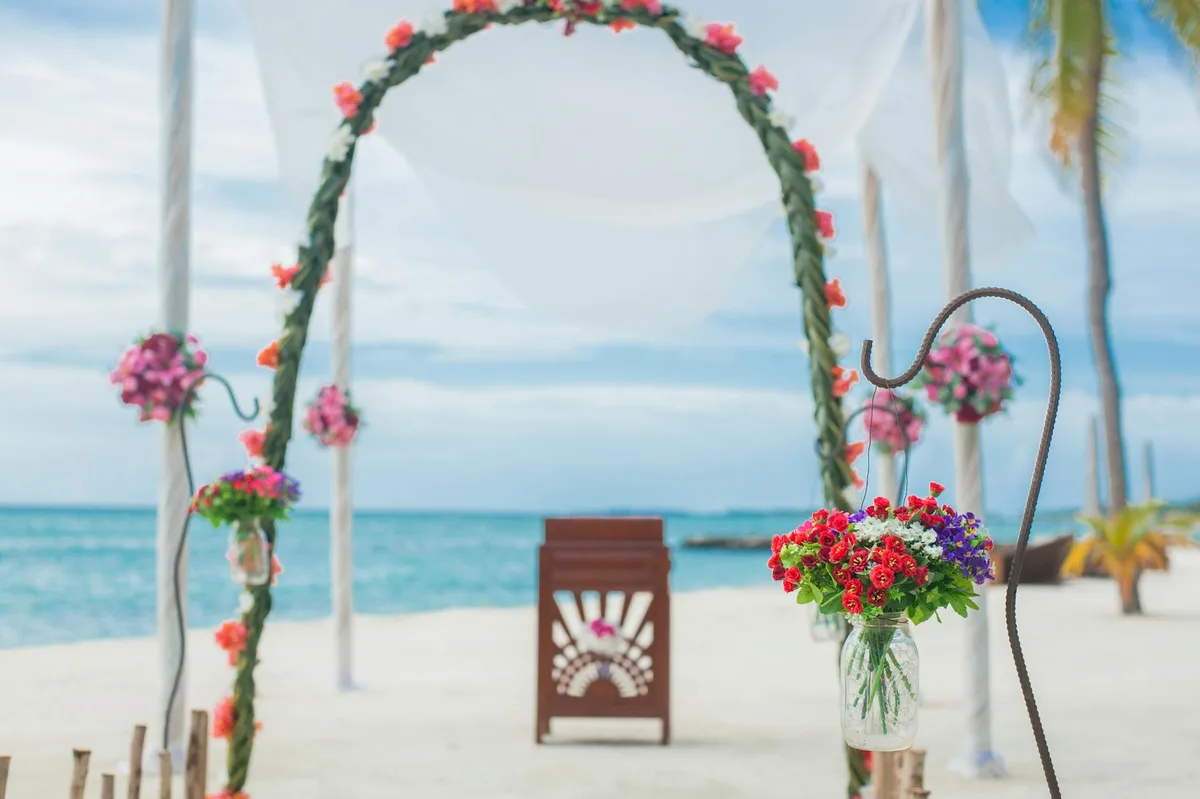 Allestimento nozze in spiaggia mozzafiato con arco floreale e sfondo oceano