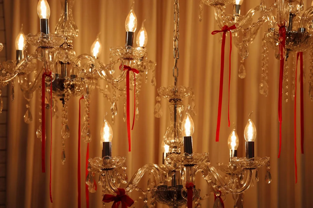 Lampadari di cristallo con nastri rossi che emanano luce calda