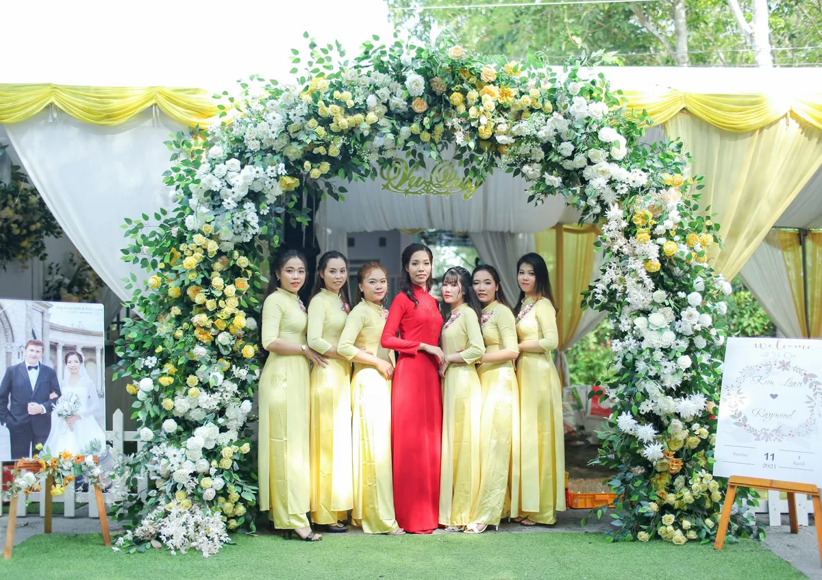 Lebhafte vietnamesische Hochzeitsszene mit Blumenbogen und traditioneller Kleidung