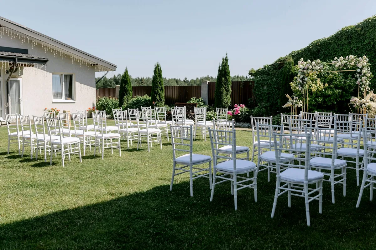 Sedie bianche in giardino per cerimonia nuziale all'aperto