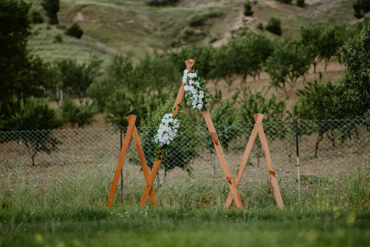 Arco in legno con fiori bianchi per matrimonio all'aperto