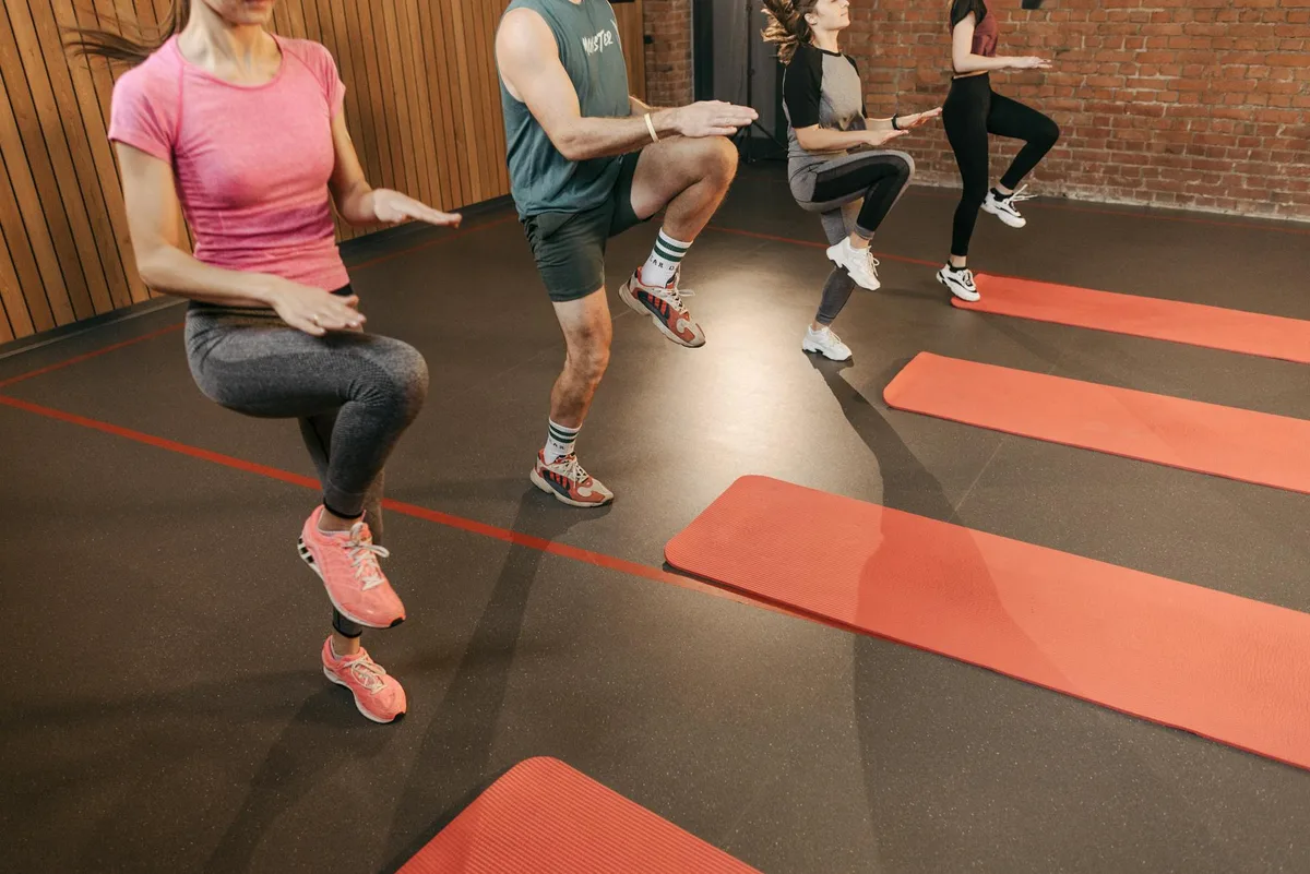 Gruppe macht High Knees im Fitnessstudio auf Yogamatten