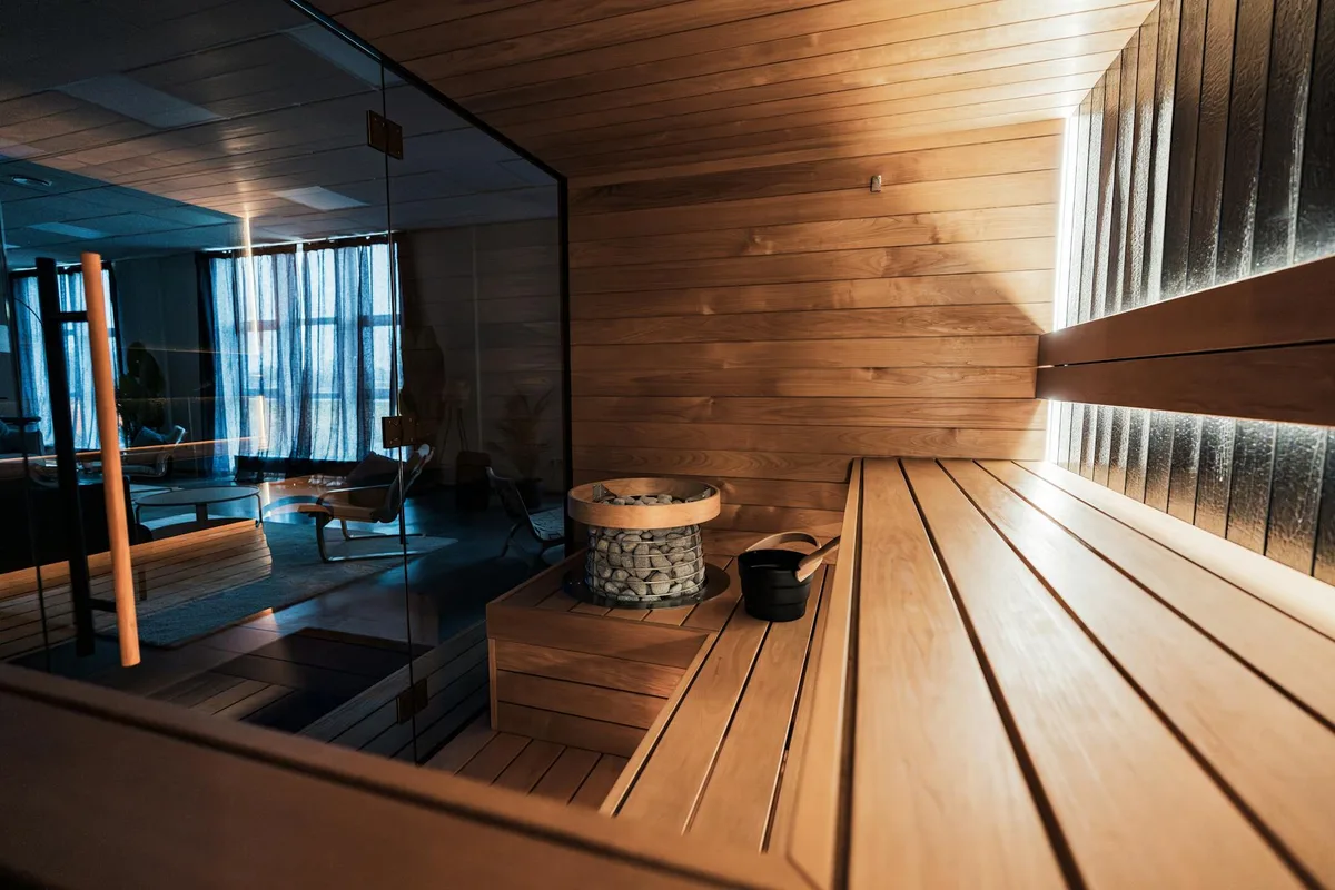Sauna indoor di lusso con design nordico e pannelli in legno eleganti.