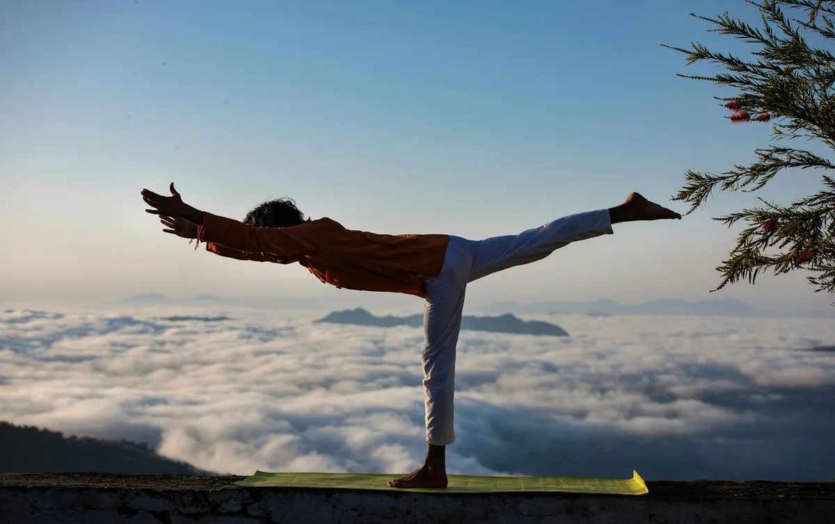Yoga in posizione guerriero su nuvole all'alba