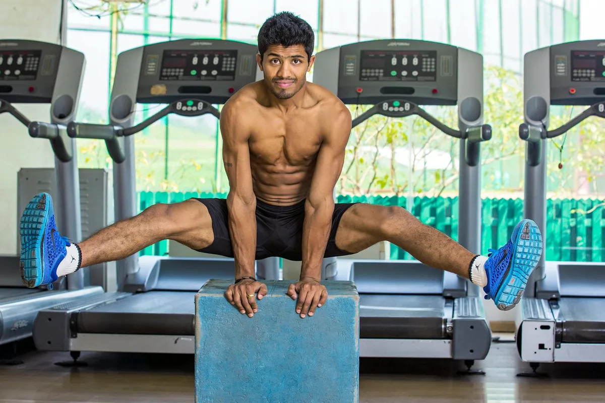 Oberkörperfreier Muskelmann beim Calisthenics in einem Indoor-Fitnessstudio in Chandigarh, Indien.