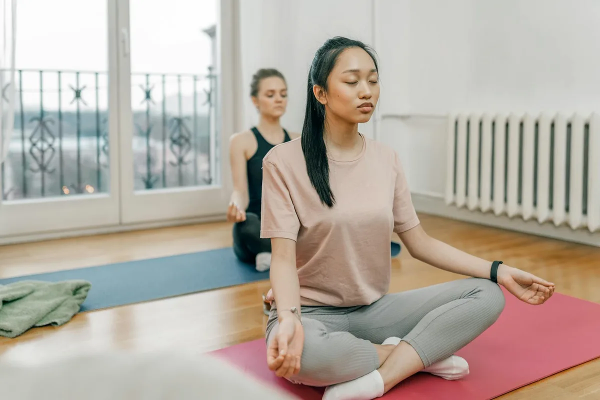 Due donne in yoga in interni sereni, meditazione.