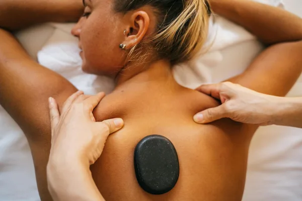 Frau erhält Hot-Stone-Massage im Spa für Entspannung und Wellness